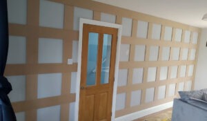 Hand-painted grid panelling in warm beige with crisp white frames