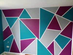 Bold geometric feature wall in teal, magenta and grey